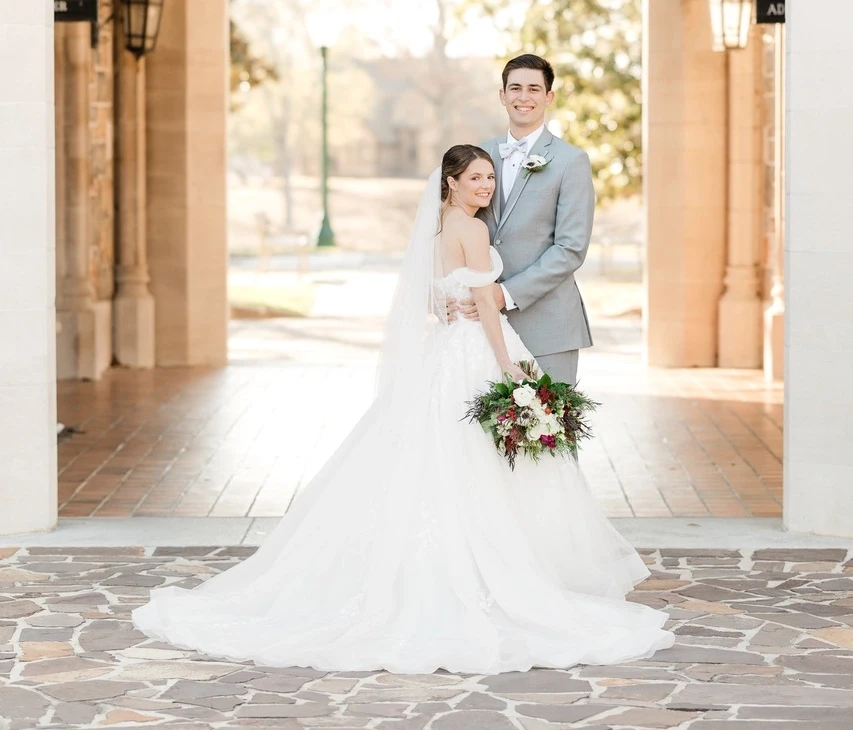 Сouple wearing a white gown and a gray suit