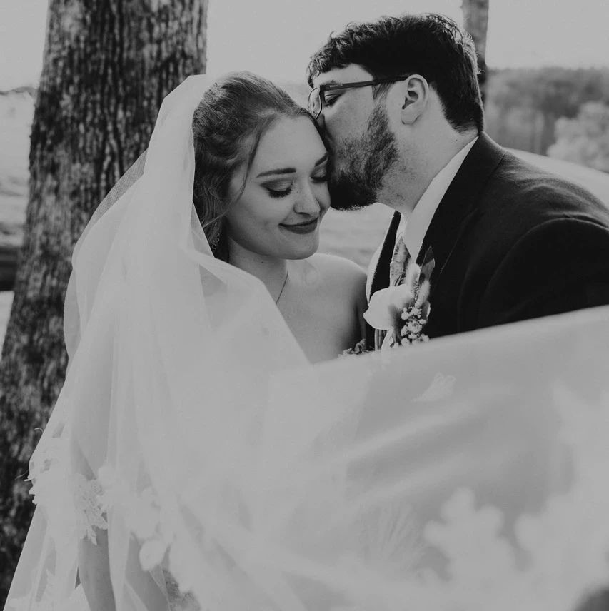 Сouple wearing a white gown and a blue suit