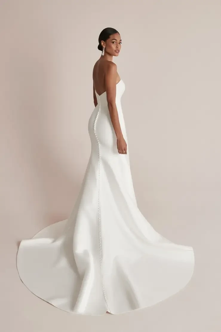 model is wearing a strapless fit and flare justin alexander wedding dress