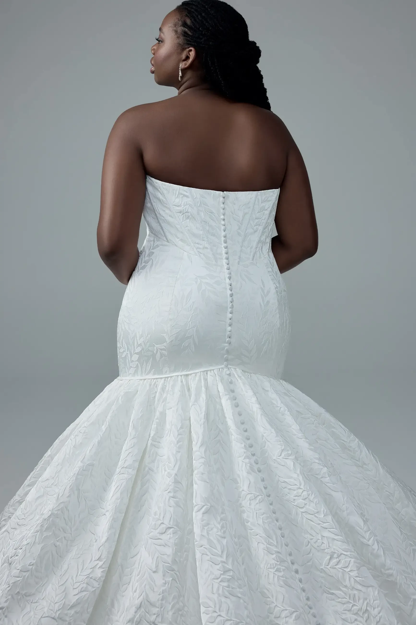 model is wearing a plus size strapless mermaid wedding dress