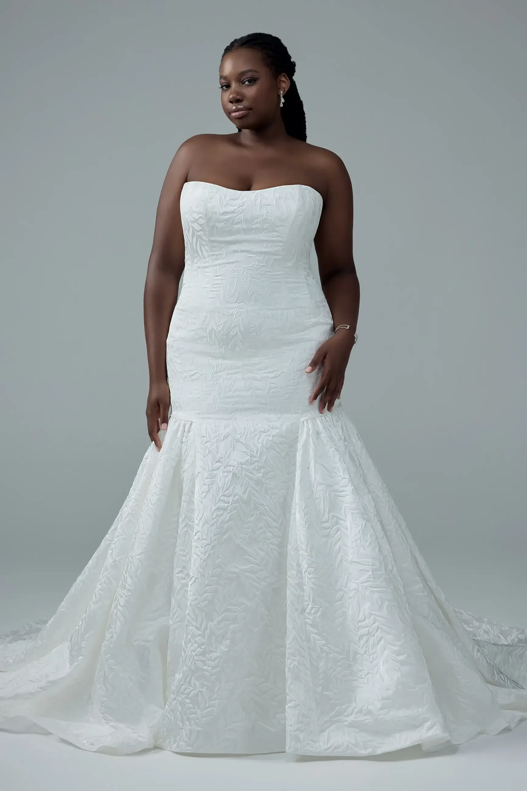 model is wearing a plus size strapless mermaid wedding dress
