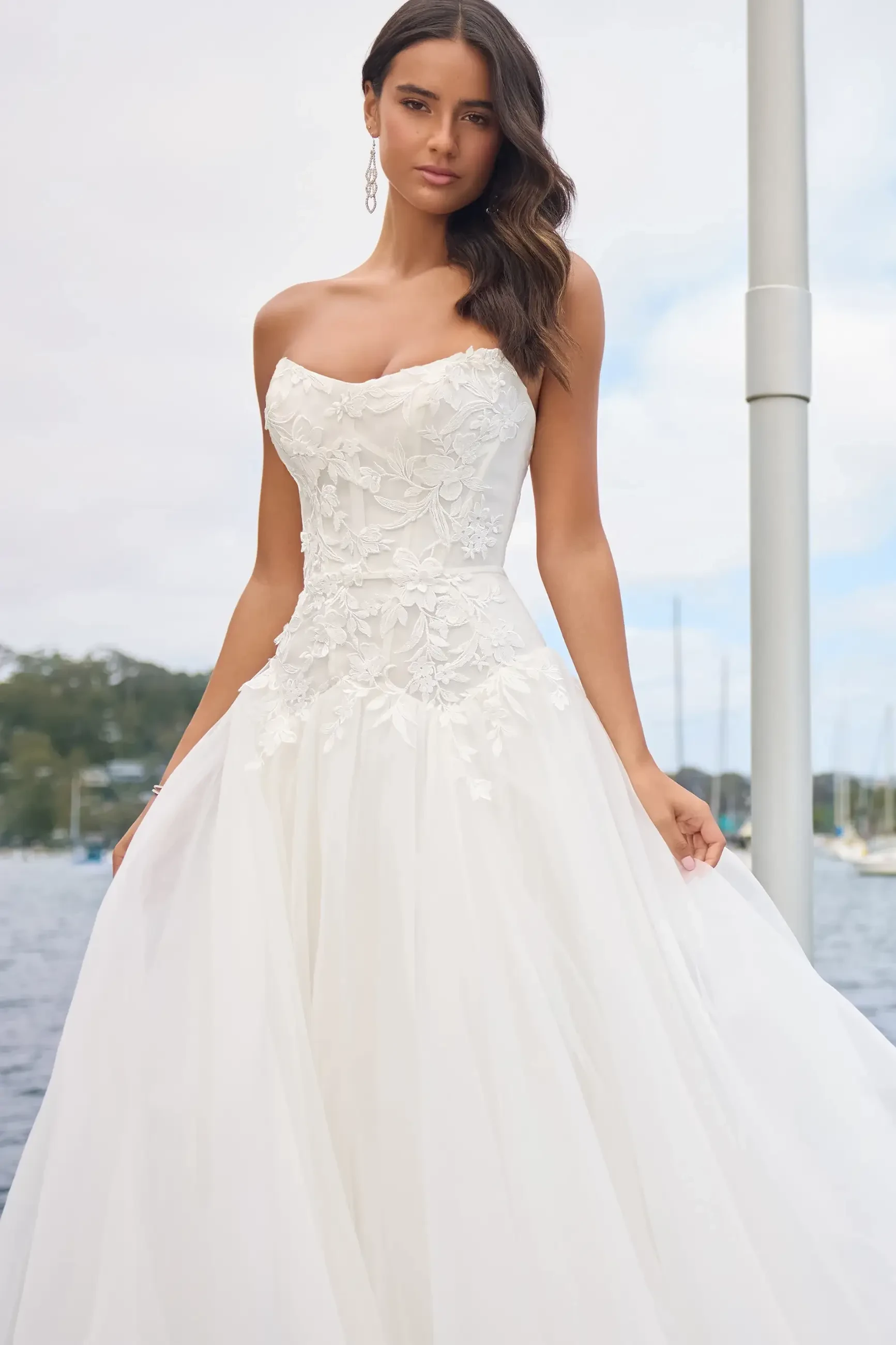 Model is wearing a strapless drop-waist gown with a voluminous organza A-line skirt
